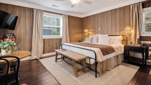A bedroom with a bed, bedside tables, a ceiling fan, a TV, and a window with curtains. - Chattanooga Cottage with Free Breakfast (Lookout Mountain)