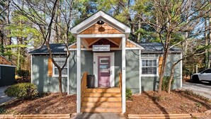 A small, single-story building with a porch and a sign that reads 'Chattanooga.' - Chattanooga Cottage with Free Breakfast (Lookout Mountain)