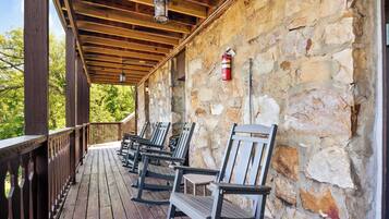 A covered porch with wooden benches, stone walls, and a fire extinguisher.
