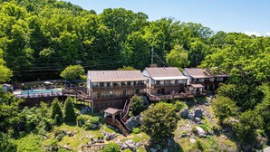 A multi-story building with a pool, surrounded by lush greenery and rocky terrain. - Historic Riverview Inn - King Room Three (Chattanooga)