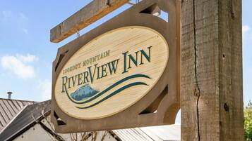 A wooden sign for Riverview Inn with a mountain graphic.