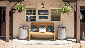 A bench with a sign for Riverview Inn, a hanging lantern, and two potted plants. - Historic Riverview Inn - King Room Five (Chattanooga)