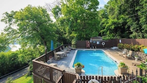 A swimming pool with a deck, surrounded by trees and a wooden fence. - Historic Riverview Inn - King Room Seven (Chattanooga)