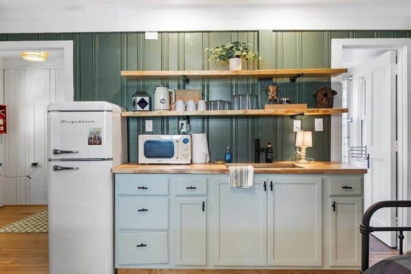 Eine Küche mit Kühlschrank, Mikrowelle und Holzböden.