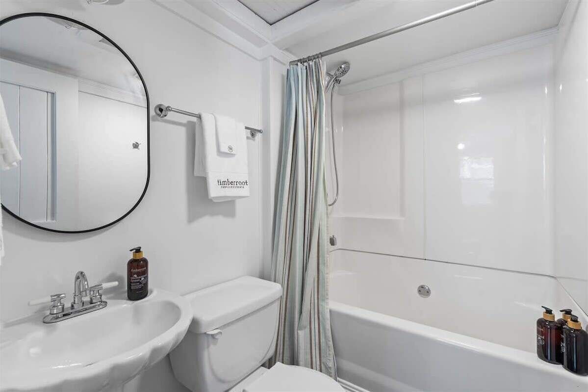 Un baño con lavabo, inodoro, bañera y cortina de ducha.