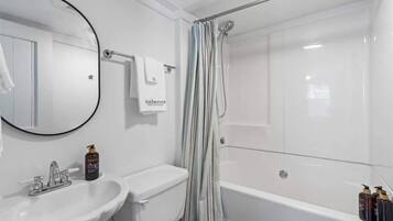 Un baño con lavabo, inodoro, bañera y cortina de ducha.