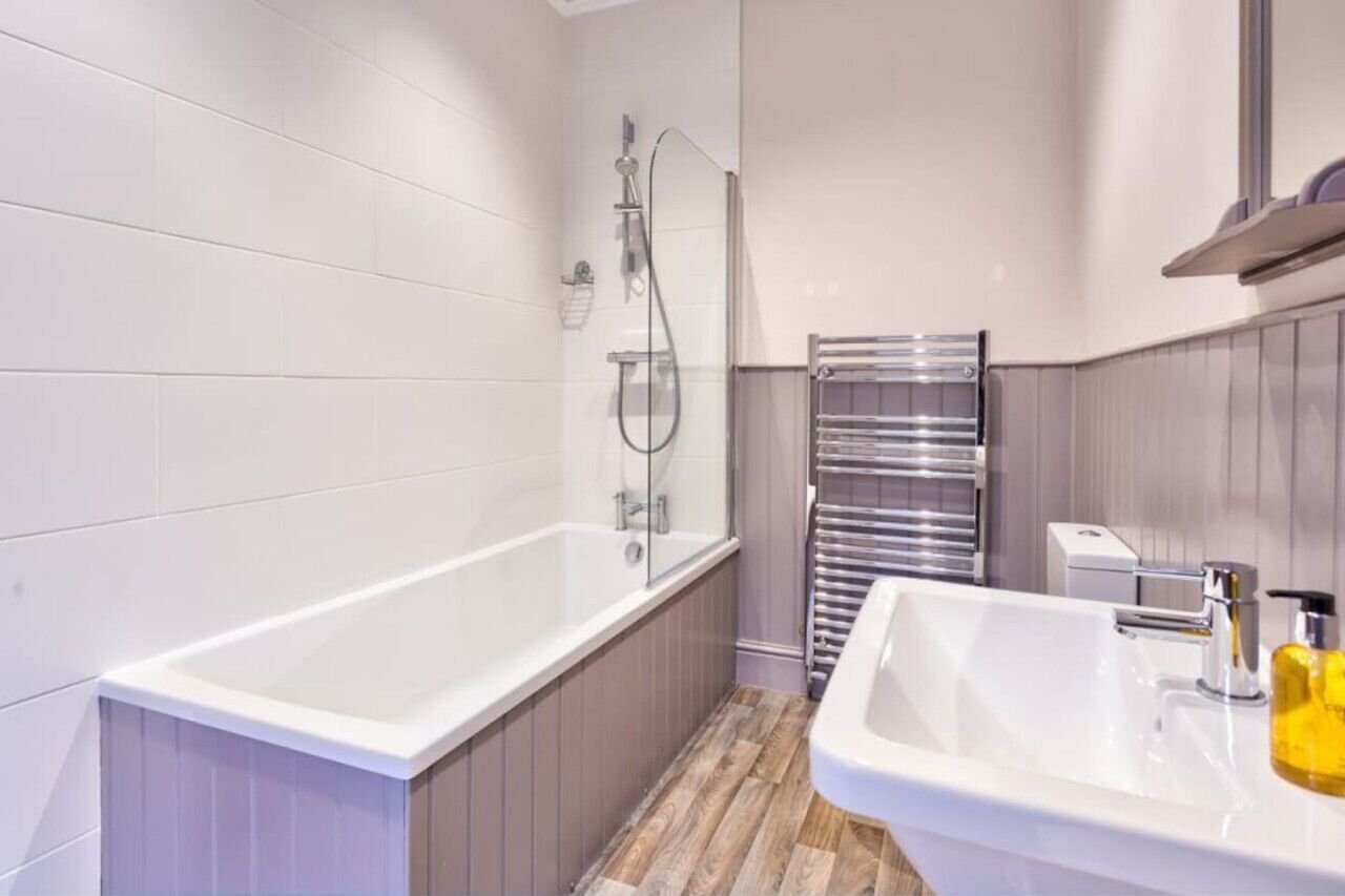 A modern bathroom with a bathtub, a sink, and a shower.