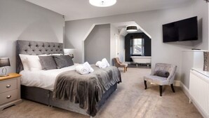A bedroom with a large bed, a chair, a TV, and a window. - The Firs - Centre of Bowness, parking for 5+ cars (Bowness-on-Windermere)