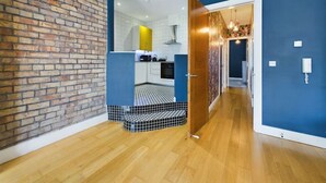 Uma cozinha moderna com parede de tijolos, piso de madeira e parede azul de destaque.