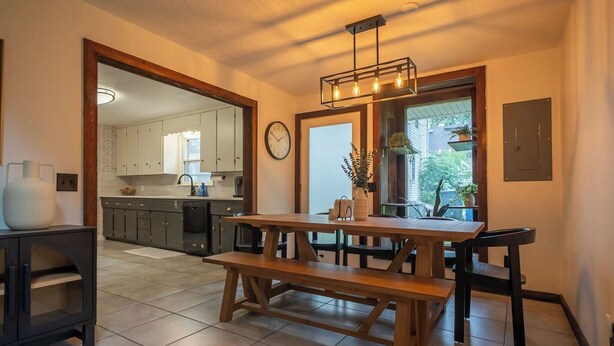 Een moderne keuken met houten kasten, een eettafel met banken en een inbouwoven.