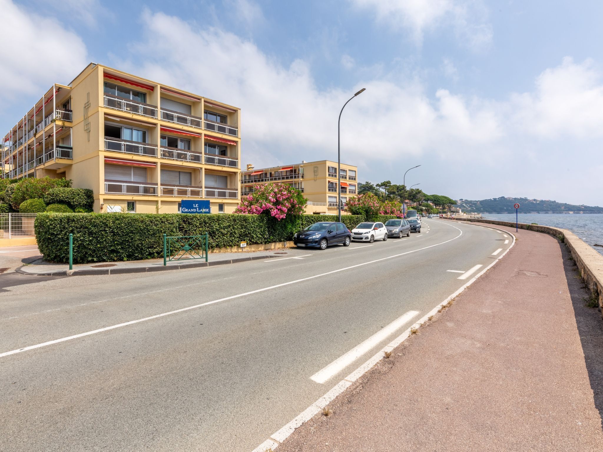 A multi-story hotel with balconies and a sign reading "Le Grand Large".