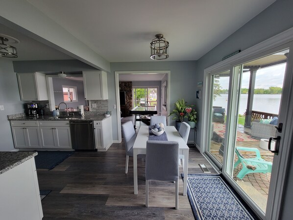A modern kitchen with granite countertops, white cabinets, and a dining area with a table and chairs.