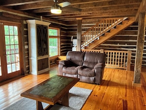 Relax in the cozy living area with a comfortable sofa, coffee table, and staircase leading to additional space.