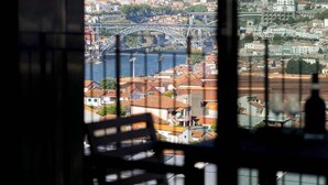 A view from a room with a large window overlooking a cityscape, including a bridge and buildings.