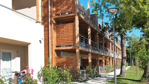A multi-story building with balconies and a covered outdoor area. - Résidence Odalys Référence Le Petit Pont by Interhome (Hourtin)