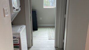 A hallway with a wooden floor, white walls, and a door leading to a room with a window. - 1br/1ba newly renovated, newly furnished downstairs unit of a duplex (San Diego)