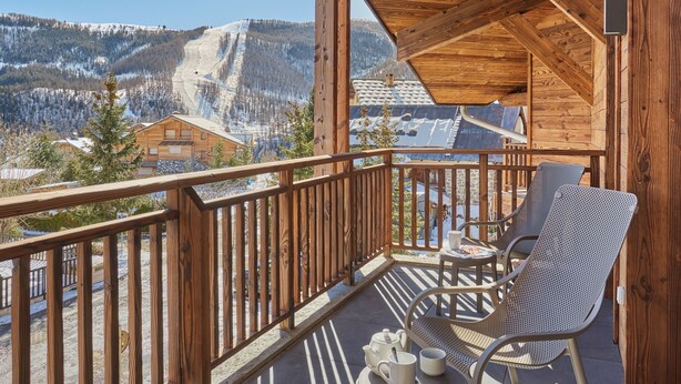 A wooden balcony with a view of a snowy mountain landscape. - Odalys Collection Le Mont d'Auron by Interhome (Auron)