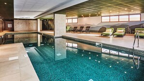 An indoor swimming pool with a tiled floor, lounge chairs, and a wall mural. - Odalys Collection Le Mont d'Auron by Interhome (Auron)