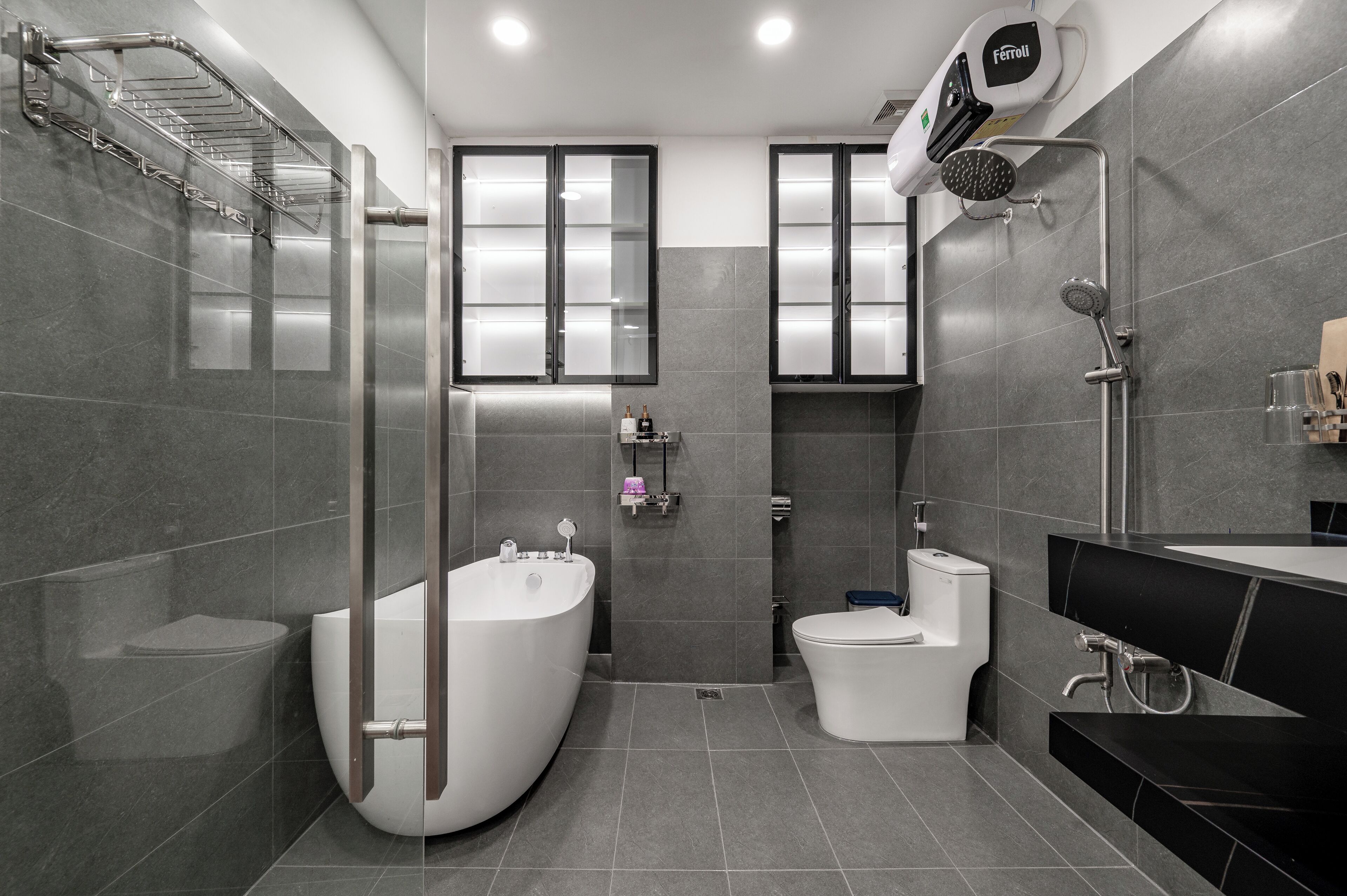 A modern bathroom with a freestanding bathtub, a toilet, a shower area, and a vanity with a mirror.