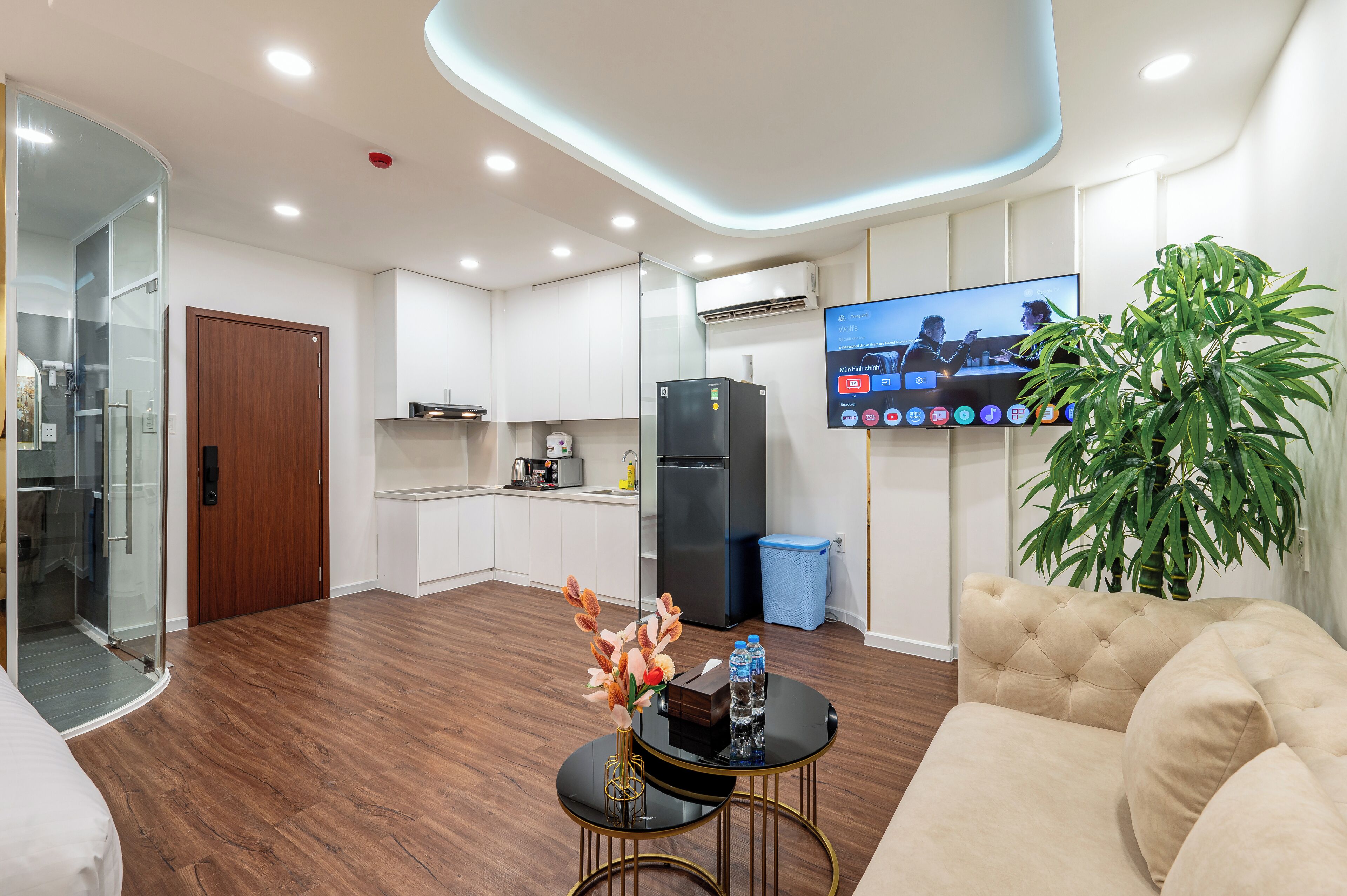 A modern living room with a sofa, a coffee table, and a TV mounted on the wall.