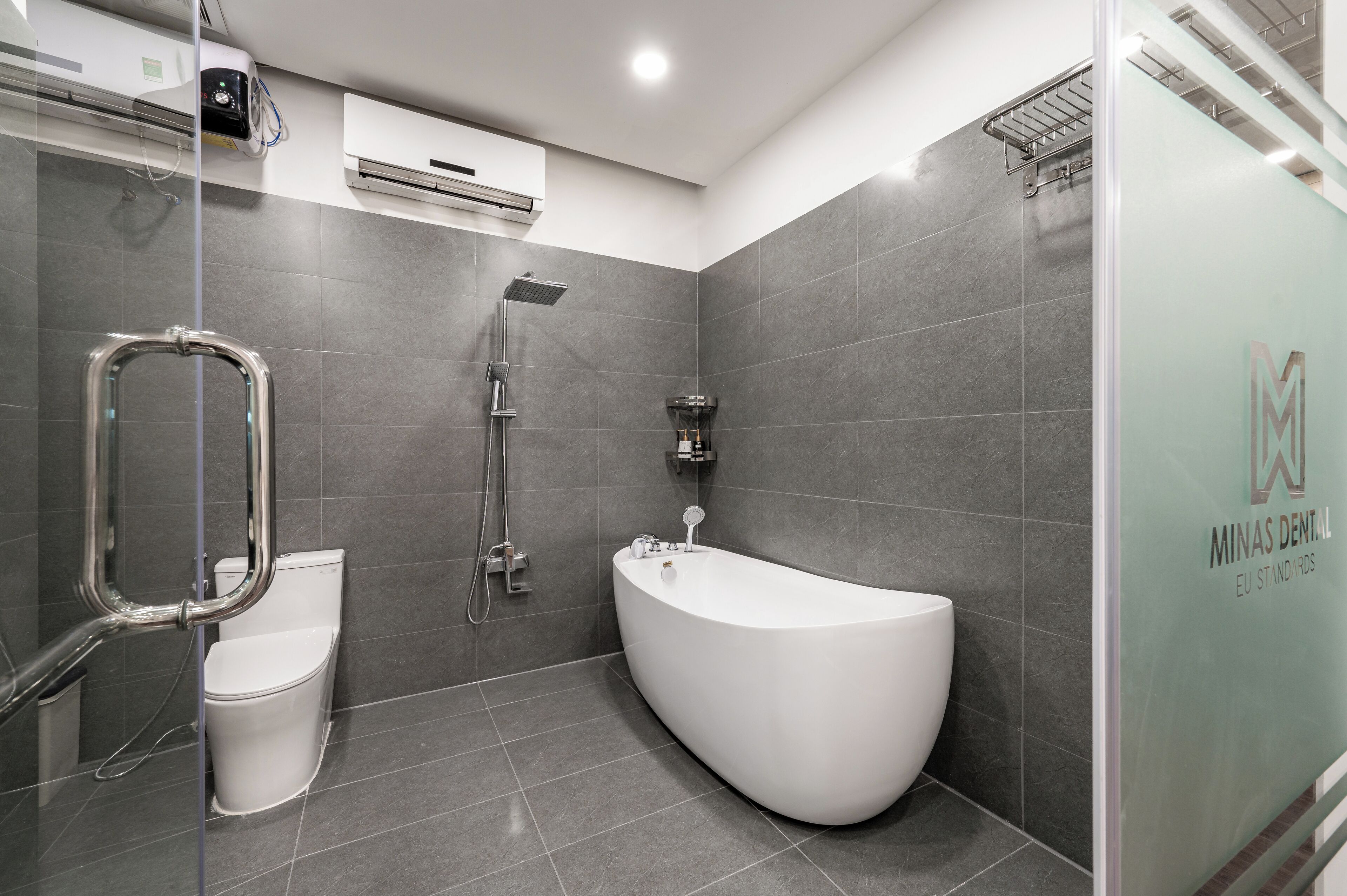 Un baño moderno con una bañera independiente, cabina de ducha de vidrio y un inodoro.