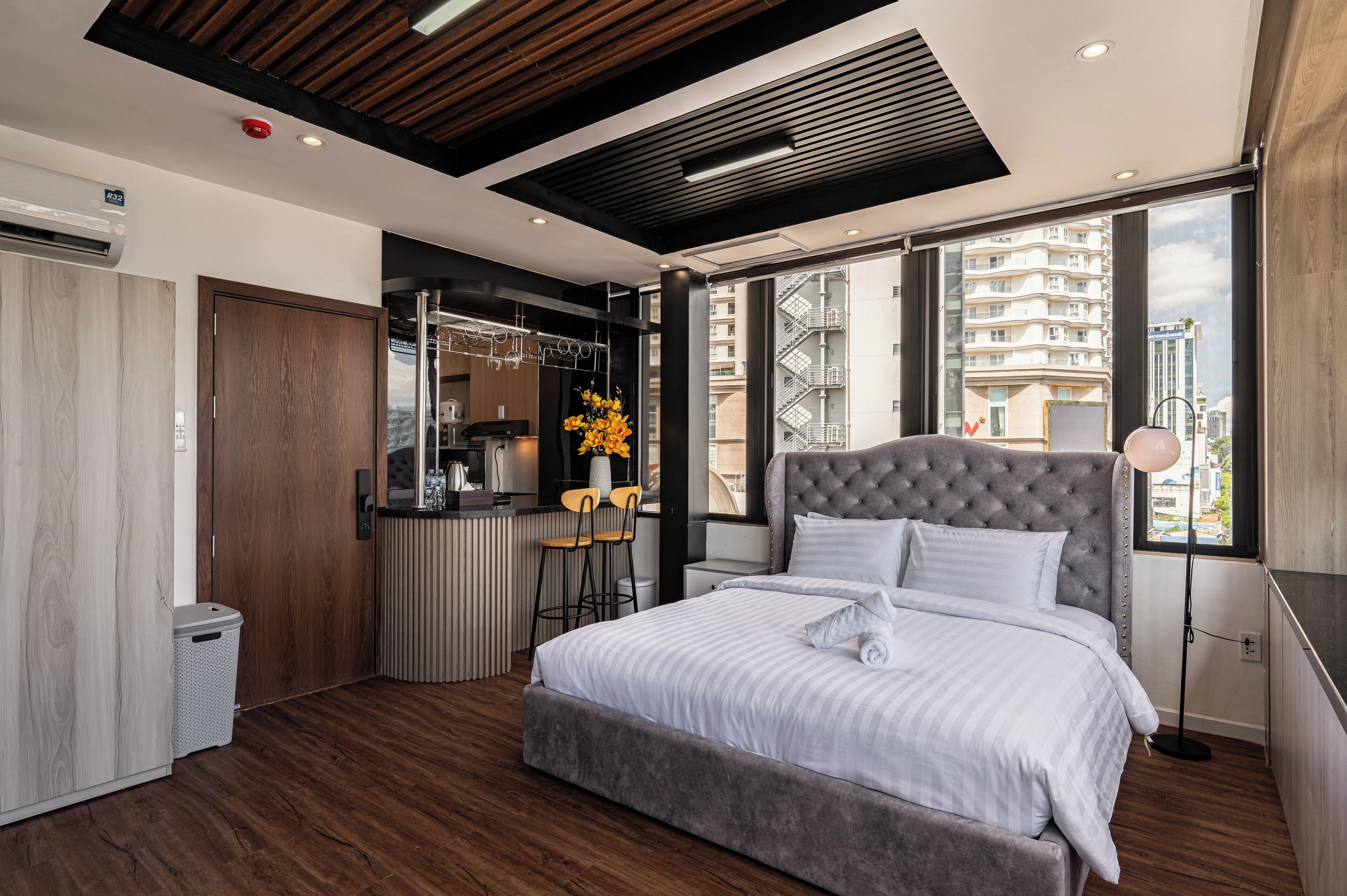 Une chambre moderne avec un grand lit, une petite kitchenette et une vue sur la ville.