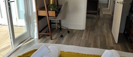 Una habitación de hotel con cama, escritorio, silla y armario.