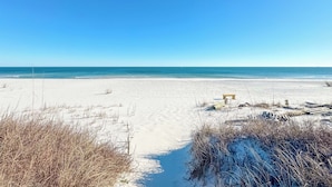 A beach with a sandy path leading to the ocean, a wooden bench, and some vegetation. - BEACHFRONT, BEAUTIFUL, FULLY RENOVATED HOUSE! (Gulf Shores)