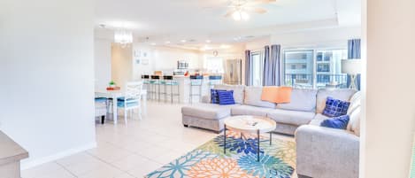 A modern living room with a sofa, coffee table, and dining area.