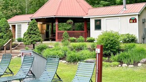Un petit bâtiment avec un toit rouge, une véranda et une enseigne indiquant qu’il s’agit d’un centre de bien-être.