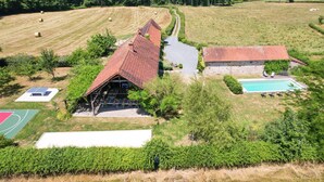 Ein ländliches Anwesen mit Scheune, Schwimmbad und Tennisplatz.