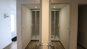 Ein moderner Raum mit Glastrennwand, Holzboden und weißer Tür.