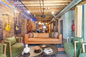 Un coin salon confortable avec un canapé, des fauteuils et une table basse.