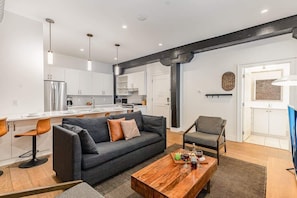 A modern apartment with a living room, kitchen, and dining area.