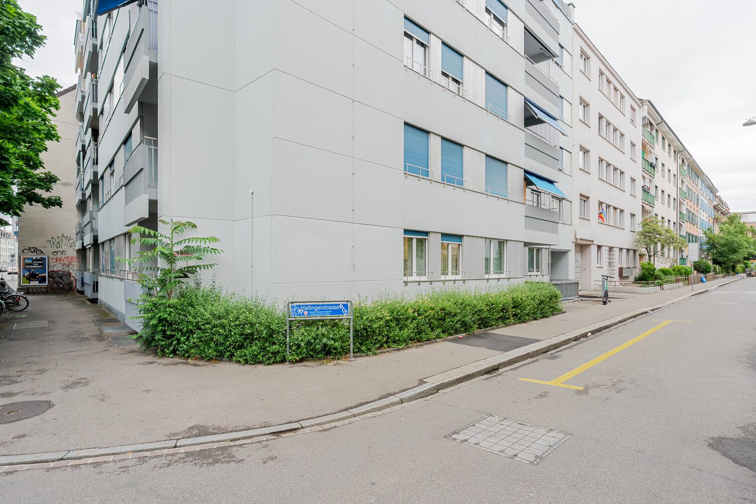 A modern apartment building with a sign indicating 'Hallingerstrasse'.