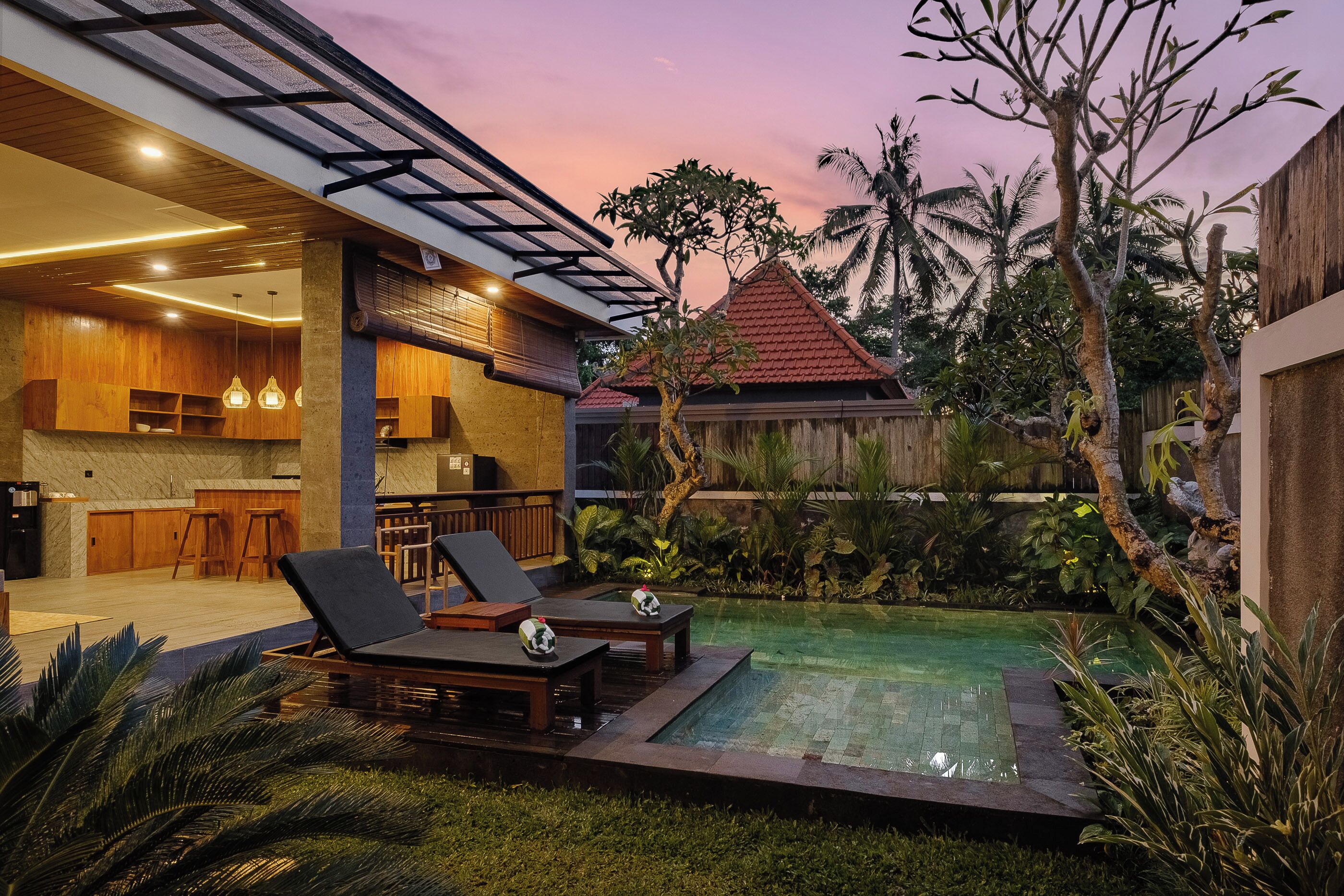 A modern house with a swimming pool, wooden furniture, and a kitchen area.