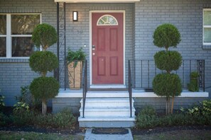 Une maison avec une porte rouge, une boîte aux lettres et une plaque portant le numéro 511.