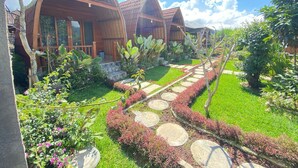 A row of wooden cabins with a stone pathway leading to the entrance. - Kintamani Angel (Kintamani)
