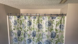 Cortina de ducha con estampado floral.