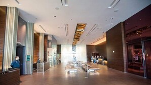 A spacious lobby with a reception desk, seating area, and a large window providing natural light. - Resort in Las Vegas with NO RESORT FEES & FREE VALET SERVICE! (Las Vegas)