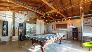 A spacious room with a pool table, a punching bag, and a billiards table. - The Latham Abode | Spa | Firepit | Game Room | NEW (Joshua Tree)
