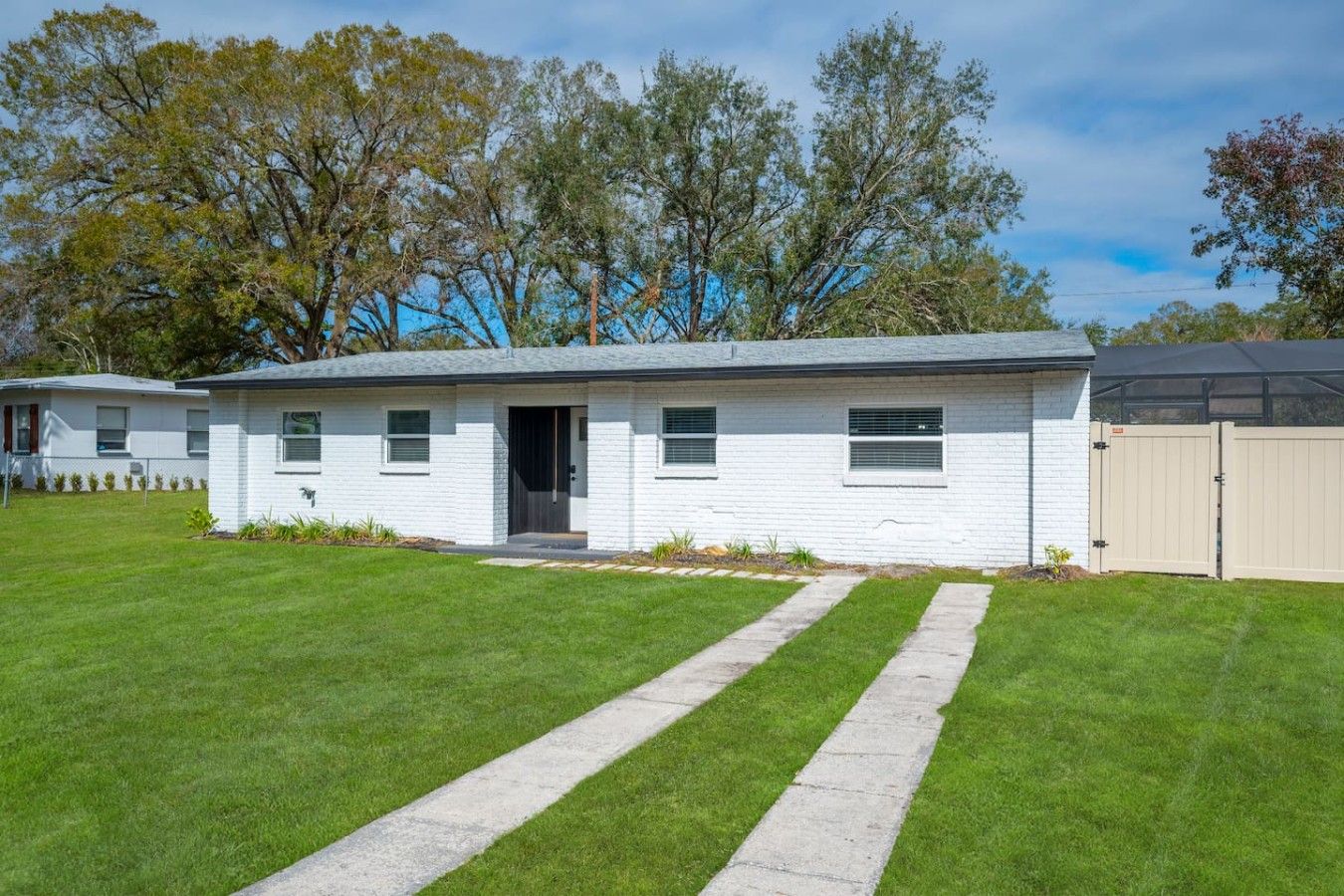 A single-story white house with a front door, windows, and a garage door.