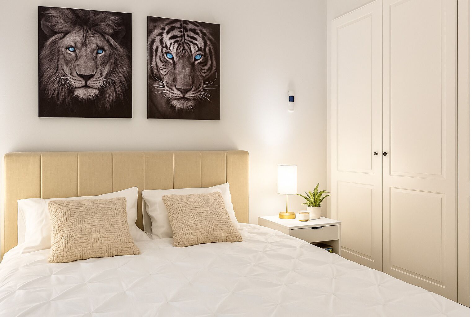 Ein Schlafzimmer mit einem Bett, zwei an der Wand befestigten Tierbildern, einem Nachttisch mit Lampe und einer Tür.