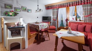 Una habitación acogedora con sofá, una mesita, televisión y chimenea.