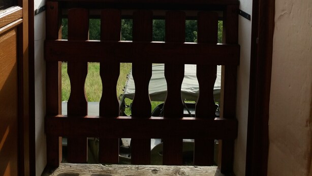 Un balcon doté d’une balustrade en bois, offrant une vue sur un paysage montagneux.