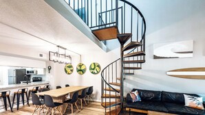 A modern interior with a spiral staircase, a dining area, and a living space.