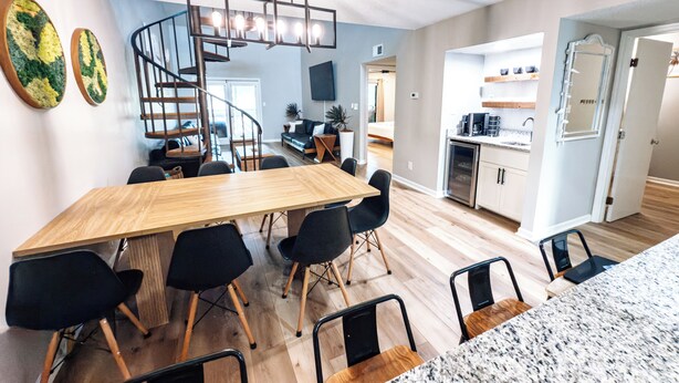 A modern kitchen with wooden cabinets, a built-in oven, and a stainless steel refrigerator.