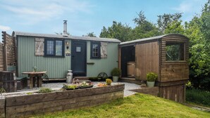 Un rustico chalet con una porta, finestre e un camino.