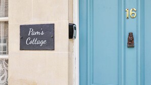 A building with a sign reading 'Pam's Cottage' and a blue door with the number 16. - 2 bedroom accommodation in Cheltenham (Cheltenham)