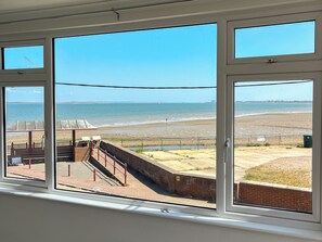 A view from a window overlooking a beach with a fence and a sign that reads "INDIAN." - 2 bedroom accommodation in Maldon (Maldon)